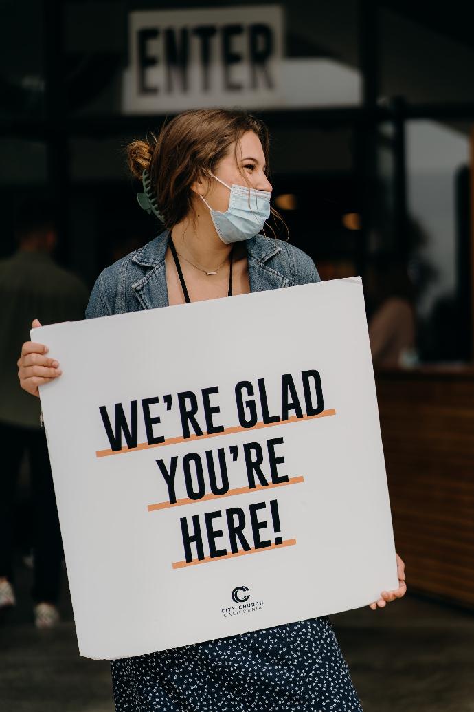 woman in blue denim jacket holding white paper